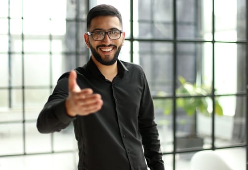 young businessman celebrating success in his home office holding fists up celebrating achievement