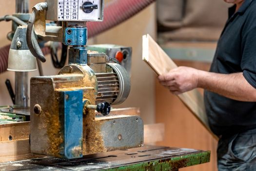 planing boards on a machine in a joinery.