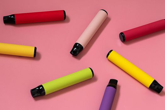 Layout of colorful disposable vapor stick on a light background. Concept of modern e-smoking, vaping and nicotine, electronic cigarettes