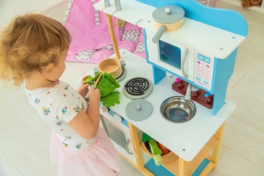 the child plays in the kitchen and cooks. Selective focus. Kid.