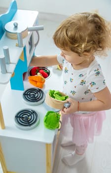 the child plays in the kitchen and cooks. Selective focus. Kid.