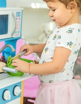 the child plays in the kitchen and cooks. Selective focus. Kid.