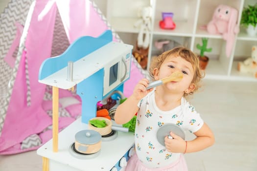 the child plays in the kitchen and cooks. Selective focus. Kid.