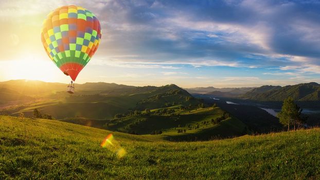 Hot air balloon above high mountain at sunset on the beauty valleys, in the mountains in Altay