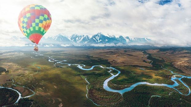 Hot air balloon above high mountain at Kurai steppe and Chuya river on North-Chui ridge background. Altai mountains, Russia. Aerial drone panoramic picture.