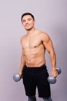 Shirtless bodybuilder showing his great body and holding dumbells.