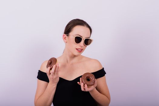 Close up shot of nude woman's body with chocolate covered donuts