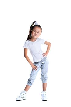 Full length portrait of pretty asian little girl in sportswear. Isolated