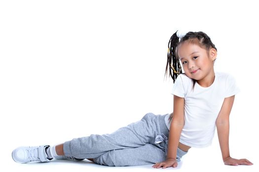 Full length portrait of asian little girl in sportswear. Isolated on white