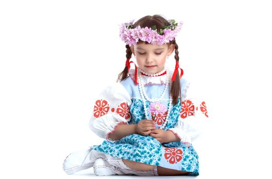 Full length portrait of little girl in slavic costume and wreath of flowers. Isolated on white