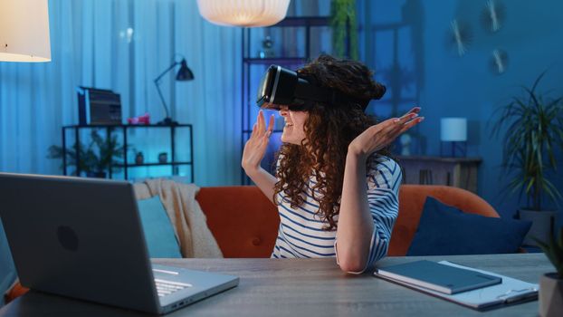 Woman using virtual reality futuristic technology VR app headset helmet play simulation 3D 360 video game watching film movie at home apartment. Girl in goggles sitting on sofa. Transition zoom effect