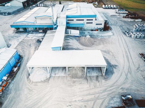 Aerial view of construction firm, asphalt base, whre gravel is being stored for the needs of road repair and other construction highway work.