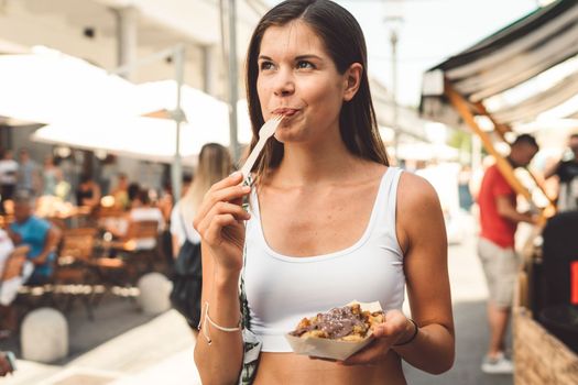 Young caucasian woman doing errands around the city, shopping at the market, going for lunch, walking around the city and enjoying a beautiful sunny day.