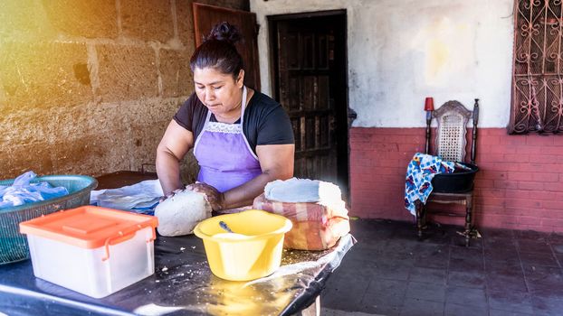 Latina woman cooking corn tortillas at home