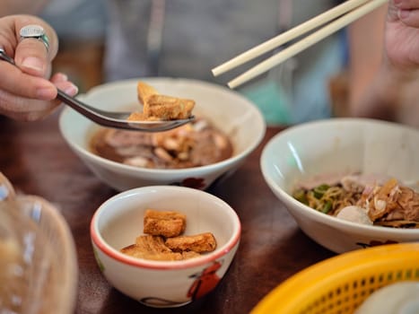 Thai Boat noodles in thicken soup added blood with Pork balls, Sliced beef and liver serve and crispy fried pork skin.