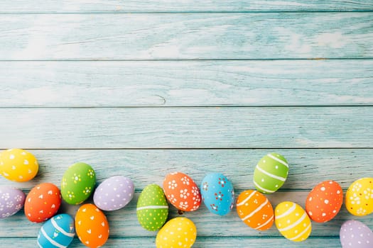 Happy Easter Day Concept. Top view holiday banner background web design white colorful easter eggs painted on blue wood background with empty copy space, celebration greeting card, overhead, template