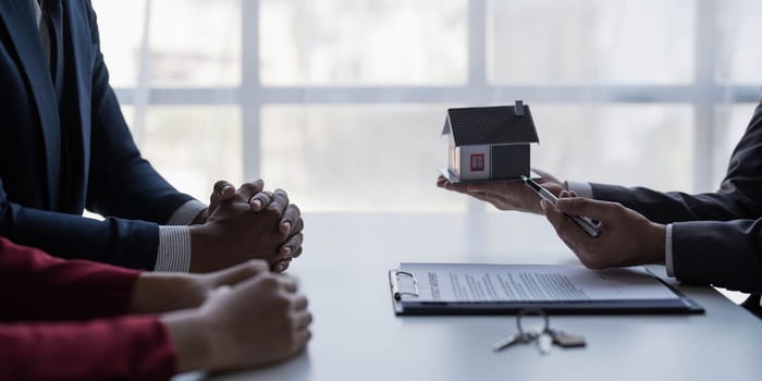 Real estate agent is discussing and explaining the terms of the home purchase contract. Businessman signing a contract agreement, mortgage, rent, lease, home insurance...