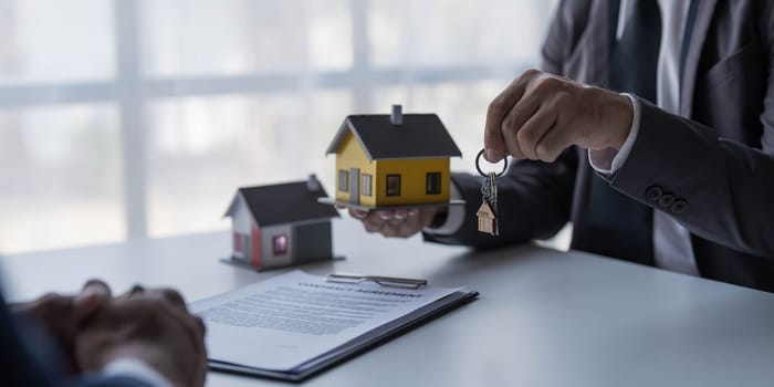 Real estate agent is discussing and explaining the terms of the home purchase contract. Businessman signing a contract agreement, mortgage, rent, lease, home insurance...