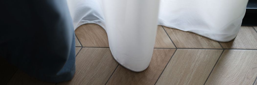 Beautiful white curtains indoors and wooden parquet floor closeup. Curtain design and floor concept