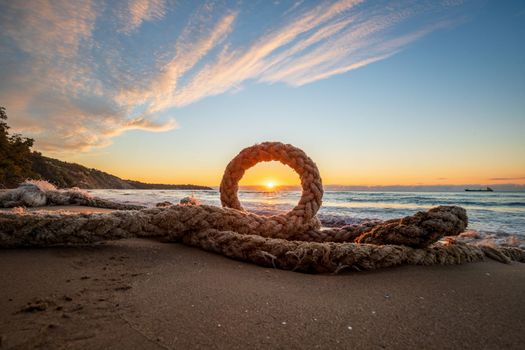 Scenic view of boat rope on the beach against with sky during sunrise