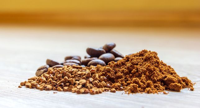 Close view of heaps of fine grinding coffee powder, coffee beans and instant coffee