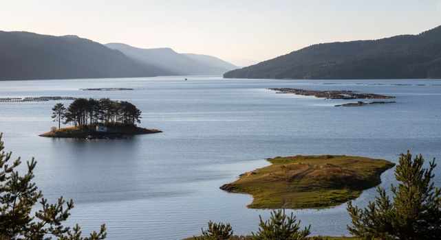 Stunning view of the blue water and hills of a lake early morning