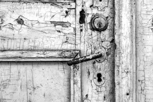 Old rustic door close up. Peeled paint. Black and white