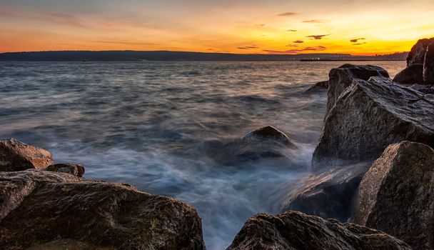 Sunset over the sea. Big rocks in the foreground