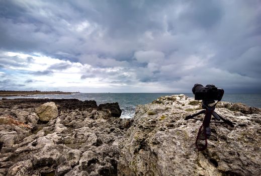 Action camera on a tripod standing on the sea coast and shooting a timelapse video