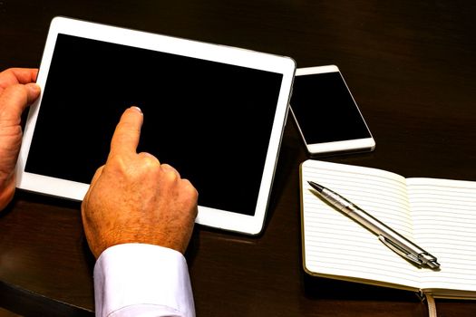 Businessman hand holding touch screen device and pointing