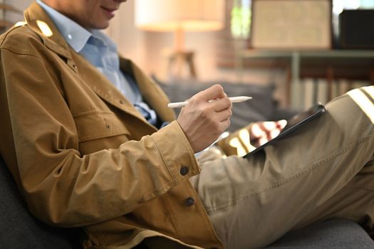 Cropped view of man freelancer working online or checking email on digital tablet. People. technology and lifestyle concept.