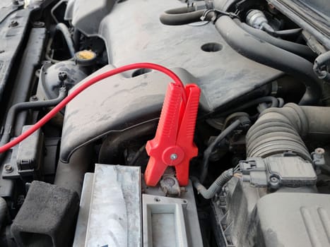 recharging a car battery close-up, open hood.