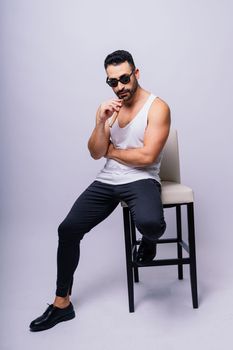 Close-up bearded caucasian man smoking cigar. Wearing white shirt. Studio portrait