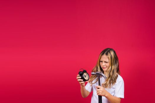 Kid girl holding hammer and alarm clock smiling with happy and cool smile on face. showing teeth.