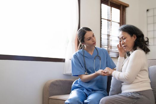 Female nurse visit old grandmother patient at home listen to complains concerns, attentive young woman doctor consulting mature senior grandma, elderly medical healthcare concept.