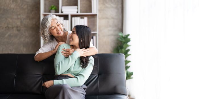 Mother and daughter hugging at home. Happy senior mom and adult daughter embracing with love.