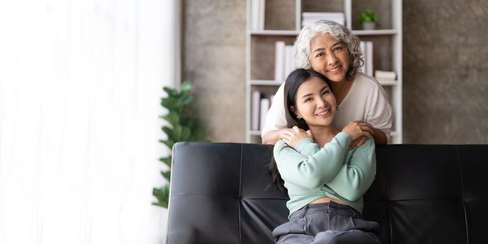 Mother and daughter hugging at home. Happy senior mom and adult daughter embracing with love.