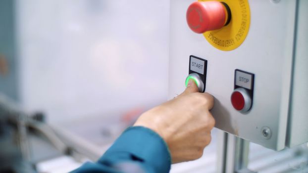 close-up, on a special shield, the hand presses the green start button, next to the red-stop. High quality photo