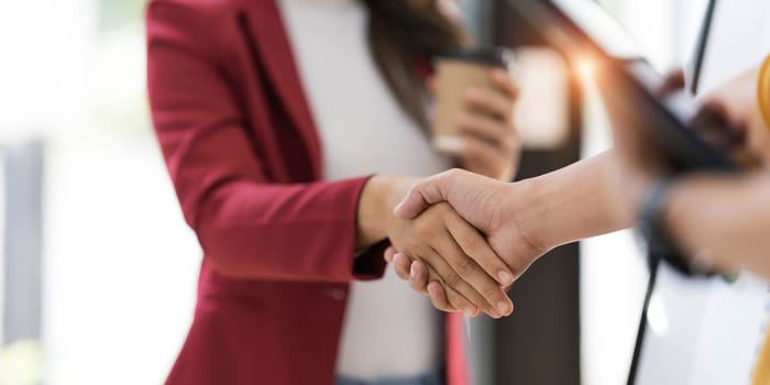 Business woman greeting with shake hands to congratulate after agreement with partner. Two business partners greeting together..