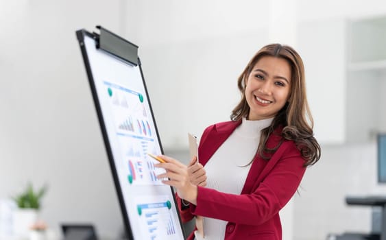 Portrait young businesswoman presentation marketing and profit with confident at office, investment and seminar for planning of finance, business woman standing explaining chart and graph...