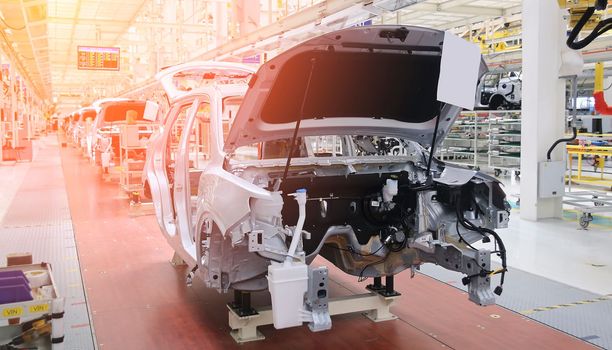 Photo of automobile production line. Modern car assembly plant. Modern and high-tech automotive industry. Conveyor of auto bodies