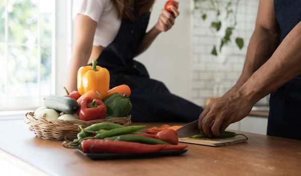 Romantic couple is cooking on kitchen. Handsome man and attractive young woman are having fun together while making salad. Healthy lifestyle concept...