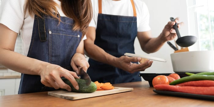 Romantic couple is cooking on kitchen. Handsome man and attractive young woman are having fun together while making salad. Healthy lifestyle concept...