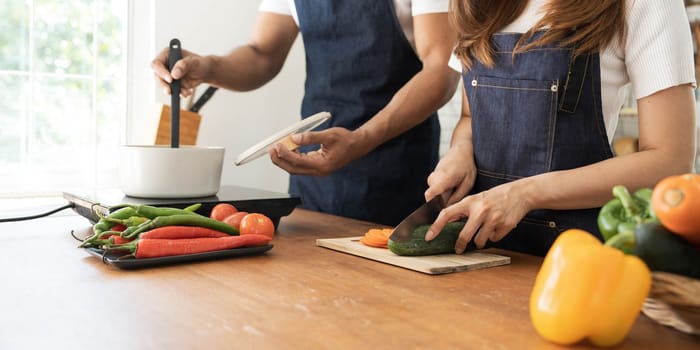 Romantic couple is cooking on kitchen. Handsome man and attractive young woman are having fun together while making salad. Healthy lifestyle concept...