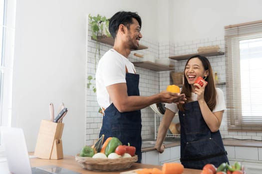 Romantic couple is cooking on kitchen. Handsome man and attractive young woman are having fun together while making salad. Healthy lifestyle concept...