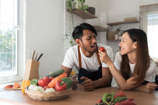 Romantic couple is cooking on kitchen. Handsome man and attractive young woman are having fun together while making salad. Healthy lifestyle concept...