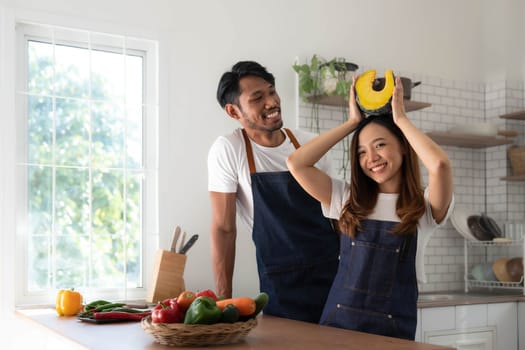 Romantic couple is cooking on kitchen. Handsome man and attractive young woman are having fun together while making salad. Healthy lifestyle concept...