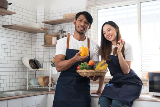 Romantic couple is cooking on kitchen. Handsome man and attractive young woman are having fun together while making salad. Healthy lifestyle concept...