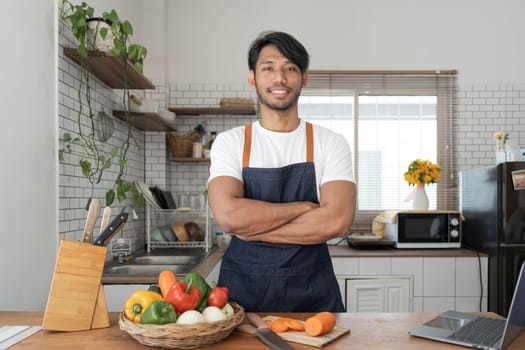 An Asian young man cooking , preparing breakfast with healthy food in kitchen at home , healthy lifestyle..