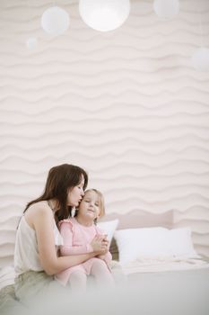 Woman in light clothes have fun with cute child baby girl 3 years old. Mommy little kid daughter on beige background studio portrait. Mother's Day love family parenthood childhood concept.